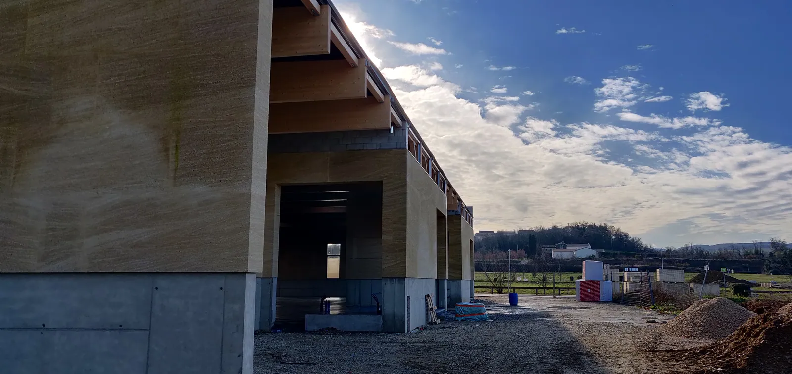 Mur en pierre massive et débord de charpente des ateliers de Grâne