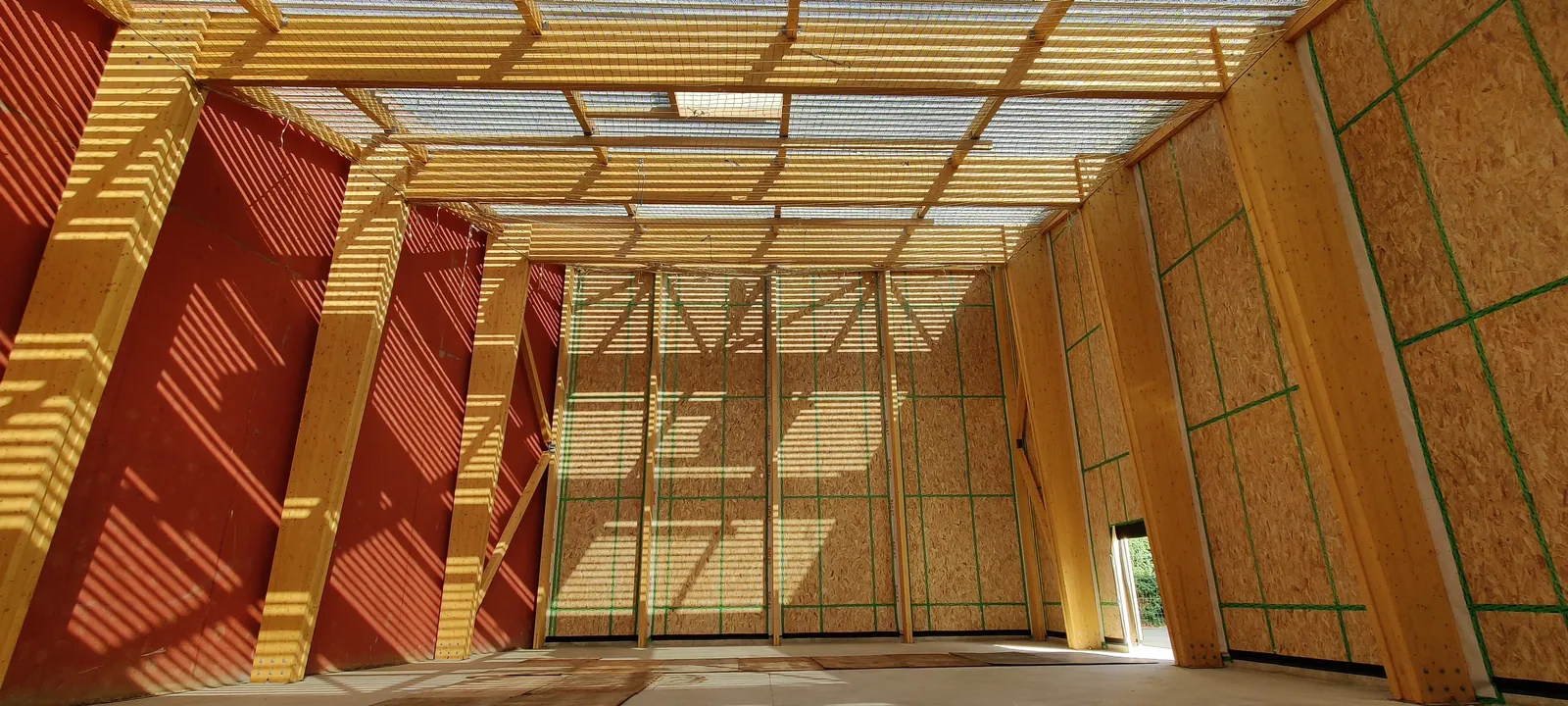 Portiques en lamellé-collé et murs à ossature bois de la salle d'escalade en cours de chantier, Valence