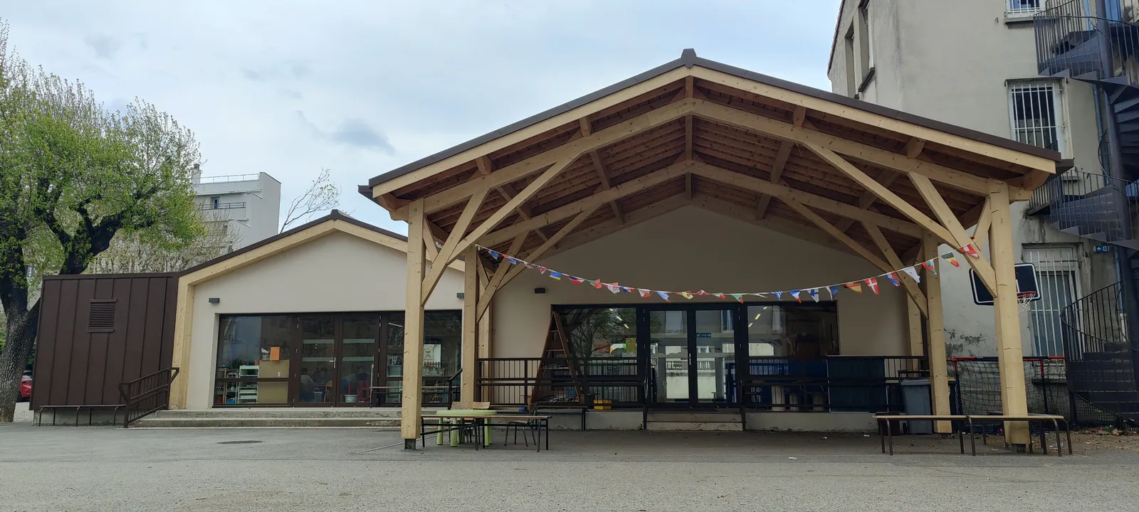 Préau à portiques en bois dans la cour de l'école Saint-Apollinaire à Valence