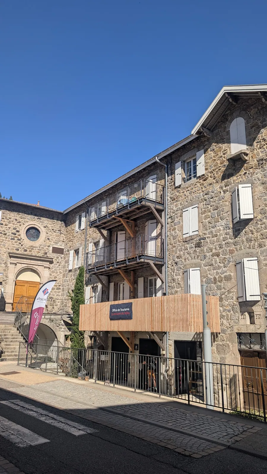 Balcons en bois rénovés de la résidence Le Couvent, vus depuis la rue